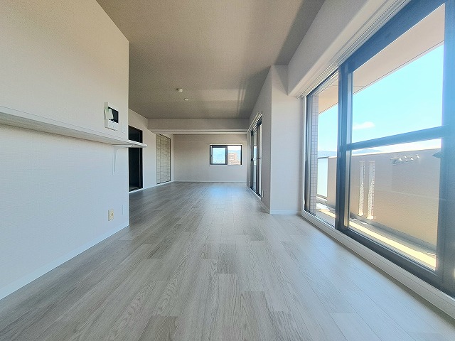 間取り変更によって誕生した、ゆとりあるリビングダイニング。大きな窓から差し込む光が部屋全体に広がり、明るく開放的な空間を演出します。ナチュラルブラウンのフローリングが空間にあたたかみを添え、落ち着いた中にも上品さを感じられる仕上がりに。キッチンや和室とも緩やかにつながるレイアウトで、家族それぞれが自由に過ごしながらも、自然と気配が感じられる心地よい距離感が魅力です。間取りは家具の配置がしやすい整った形で、暮らし方に合わせて自在にコーディネート可能。家族団らんの時間も、一人で過ごすリラックスタイムも、どちらも大切にできる空間です。心地よさと開放感を兼ね備えた、日々の暮らしを豊かにするリビングです。